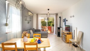 Een moderne woonkamer met een eethoek, een bank, een televisie en een open haard.