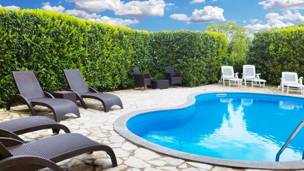 Zwembad met ligbedden en een terras van natuursteen.
