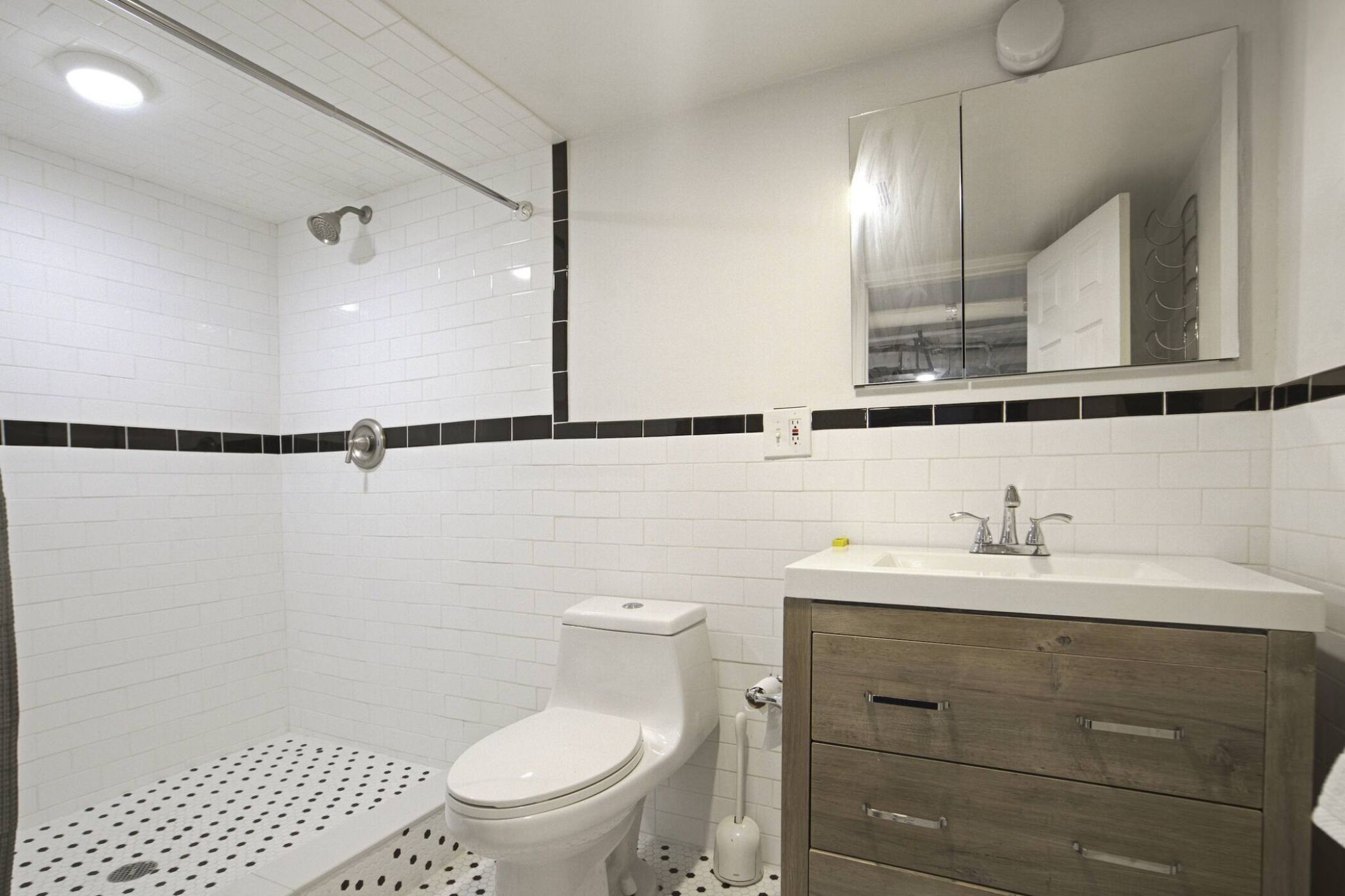 A modern bathroom with a shower, toilet, and vanity.