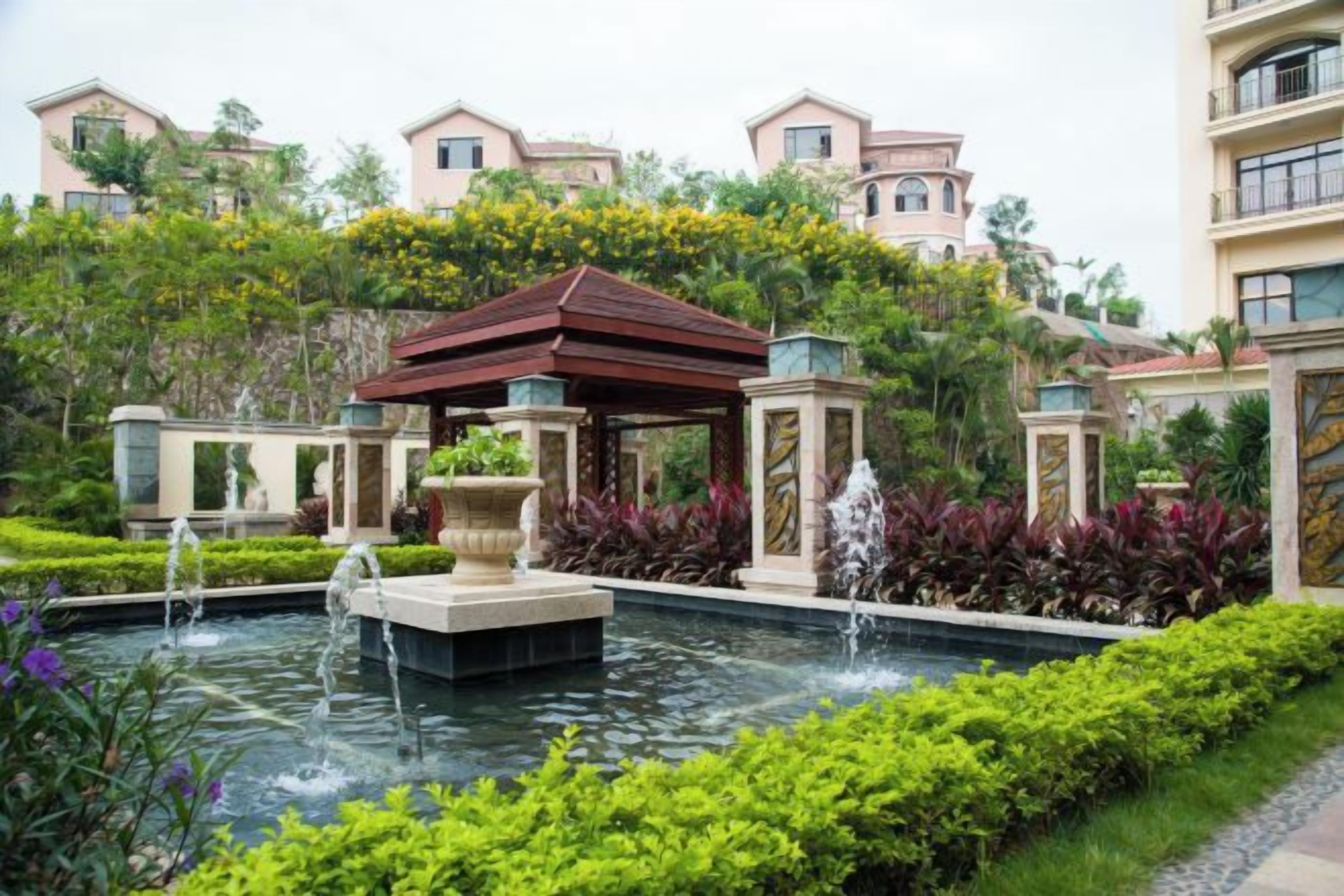 A landscaped garden with a fountain, a gazebo, and a pool.
