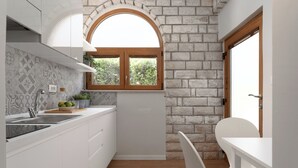 A compact kitchen with white cabinetry, a built-in oven, and a window with a wooden frame. - Studio apartment Alloro One (Istria - Novigrad) (Novigrad)