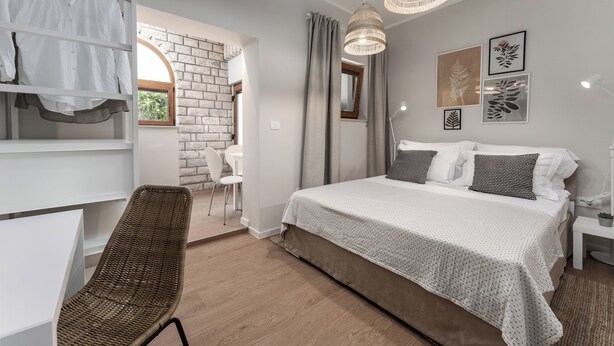 A bedroom with a bed, a chair, a desk, and a wardrobe. - Studio apartment Alloro One (Istria - Novigrad) (Novigrad)