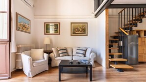 Ein Wohnzimmer mit einer Couch, einem Couchtisch und einer Treppe.