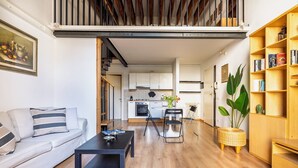 Ein modernes Wohnzimmer mit Sofa, Couchtisch und Bücherregal.
