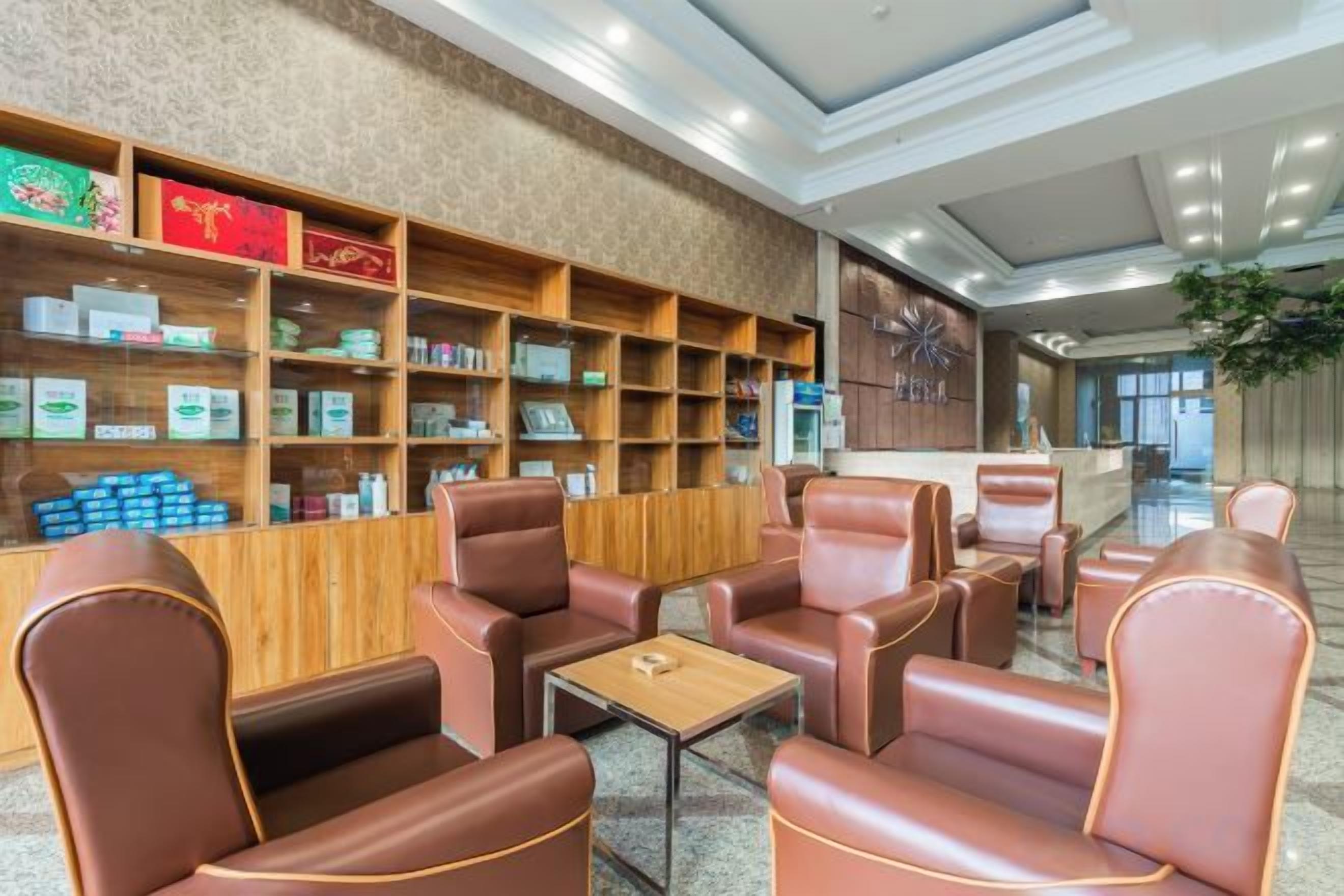 A lobby with leather seating, wooden shelves with products, and a reception desk.