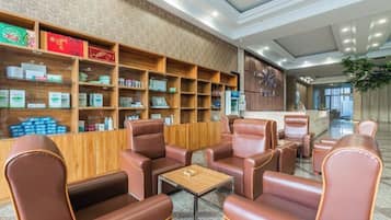 A lobby with leather seating, wooden shelves with products, and a reception desk.