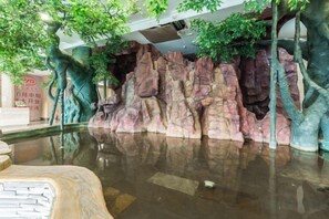 A rock formation with a reflective water surface and trees. - Huanren Qingfeng Hotel (Huanren)