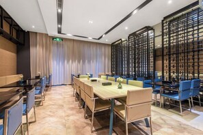 Un salón de conferencias con una larga mesa, sillas azules y un diseño interior moderno.