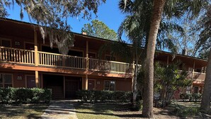 A two-story building with a stone pathway leading to the entrance. - Cozy 1-bedroom condo with WiFi, AC in lovely Westgate River Ranch (River Ranch)