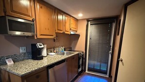 A compact kitchen with wooden cabinets, a built-in microwave, a sink, and a dishwasher. - Cozy 1-bedroom condo with WiFi, AC in lovely Westgate River Ranch (River Ranch)