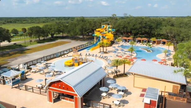 A water park with a large slide, multiple pools, and outdoor seating areas. - Cozy 1-bedroom condo with WiFi, AC in lovely Westgate River Ranch (River Ranch)