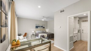 A modern bedroom with a bed, bedside tables, and a ceiling fan. - Camellia: Studio Apt, 4 Minute walk to A&M (College Station)