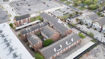 An aerial view of a multi-story building with a parking lot in front.