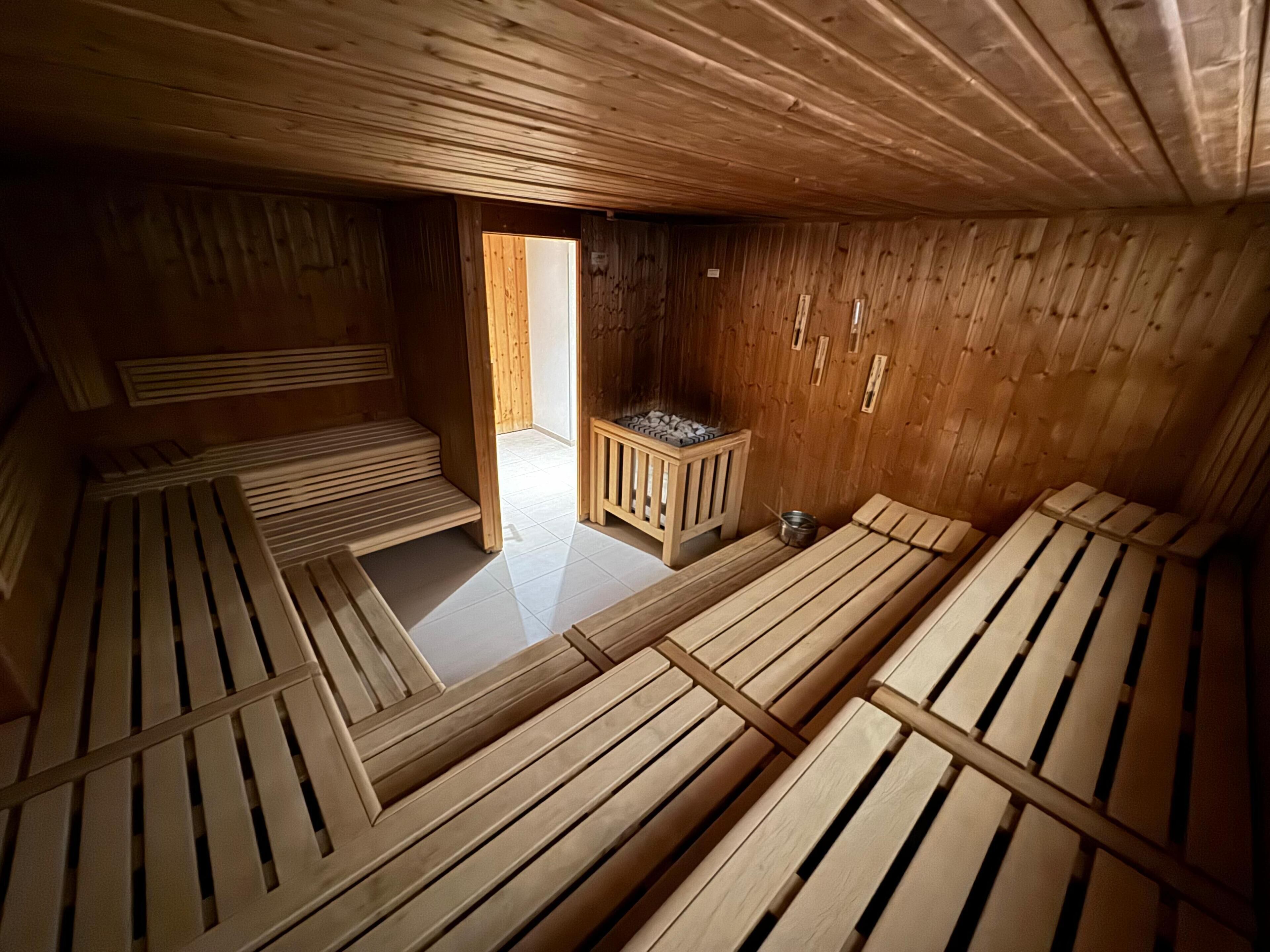 Un sauna avec des bancs en bois et un petit chauffage.