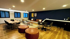 Un intérieur moderne avec une table à manger en bois, des poufs en cuir et un canapé.