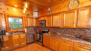 A wooden kitchen with a tiled backsplash, wooden cabinets, a microwave, and a dishwasher.
