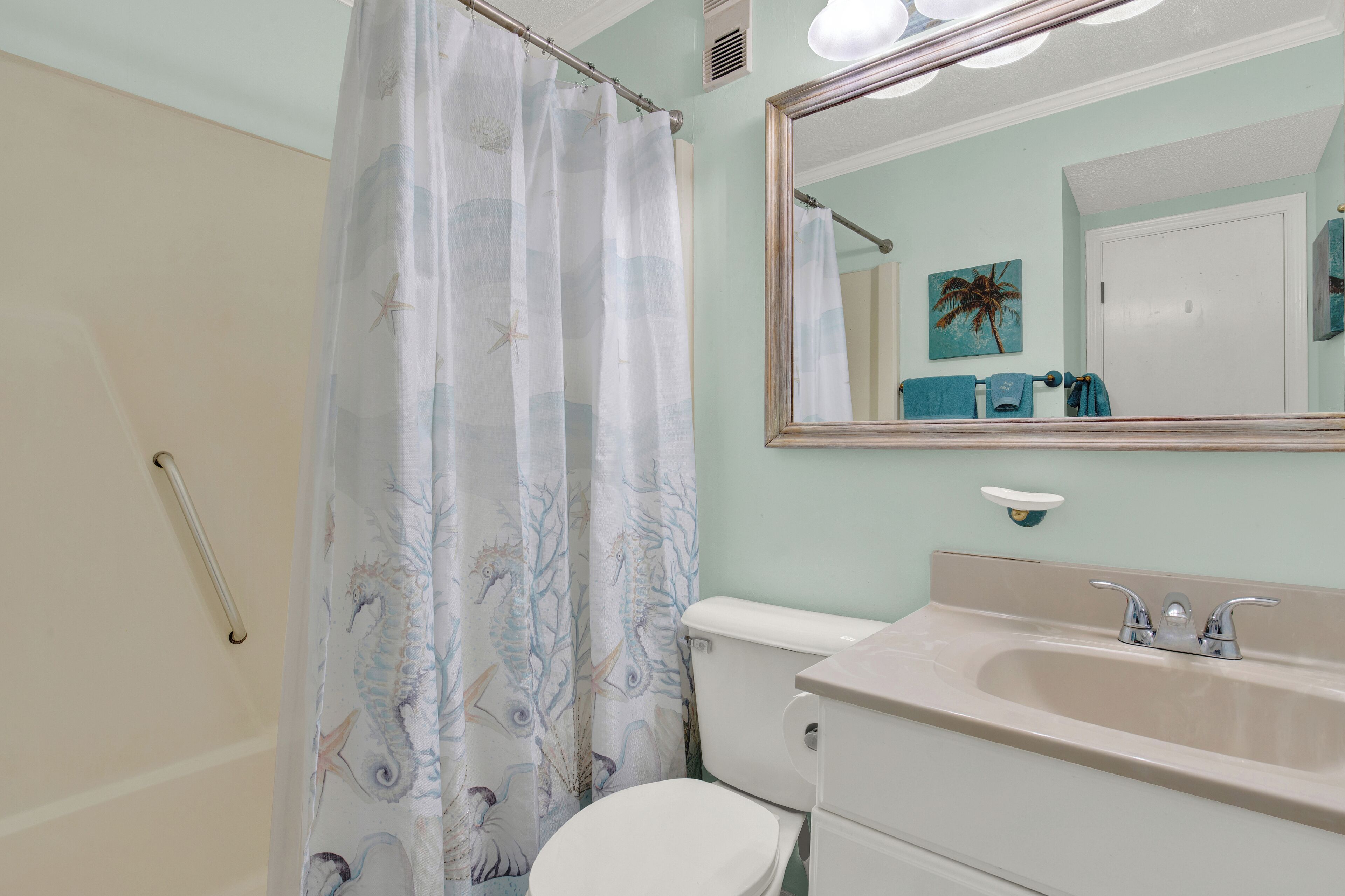 Une salle de bain avec des toilettes, un lavabo et un rideau de douche.