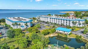 A hotel with multiple buildings, a parking lot, and a body of water. - Charming 1-bedroom condo in serene Tybee Island (Tybee Island)