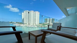 A balcony with wooden furniture and a clear view of a marina and high-rise buildings. - Marea Puerto Cancun, luxury+comfort+the best view (Cancún)