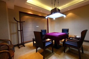 A dining area with a table and chairs, a ceiling light fixture, and a door.