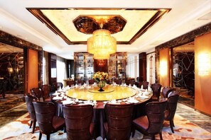 A round table with chairs, a chandelier, and a floral centerpiece in a hotel room. - Haiyan Hotel (Haiyan)