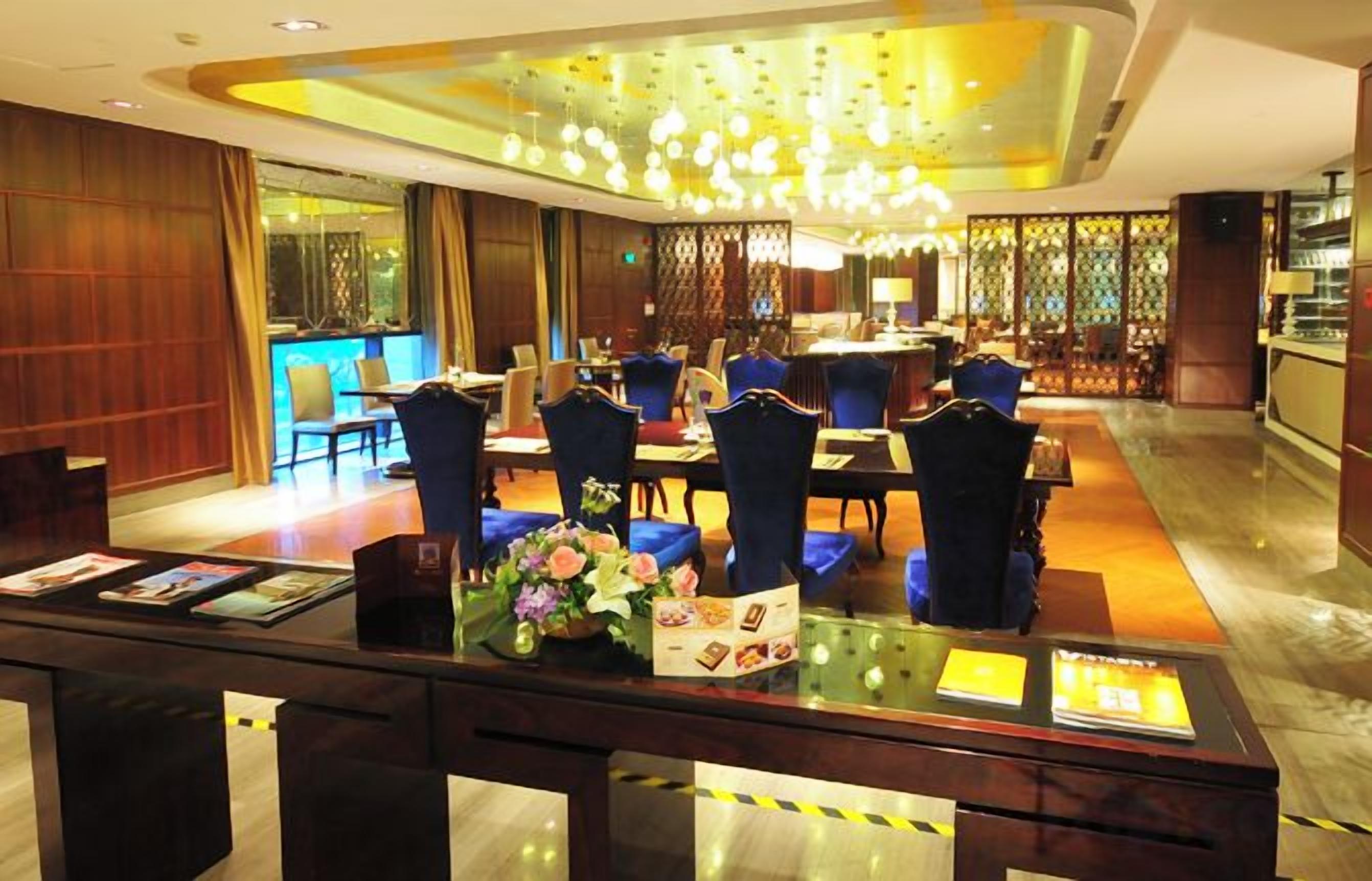 A hotel lobby with a reception desk, seating area, and a bar.