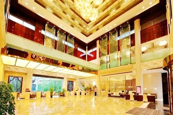 A spacious lobby with a high ceiling, multiple seating areas, and large windows. - Haiyan Hotel (Haiyan)