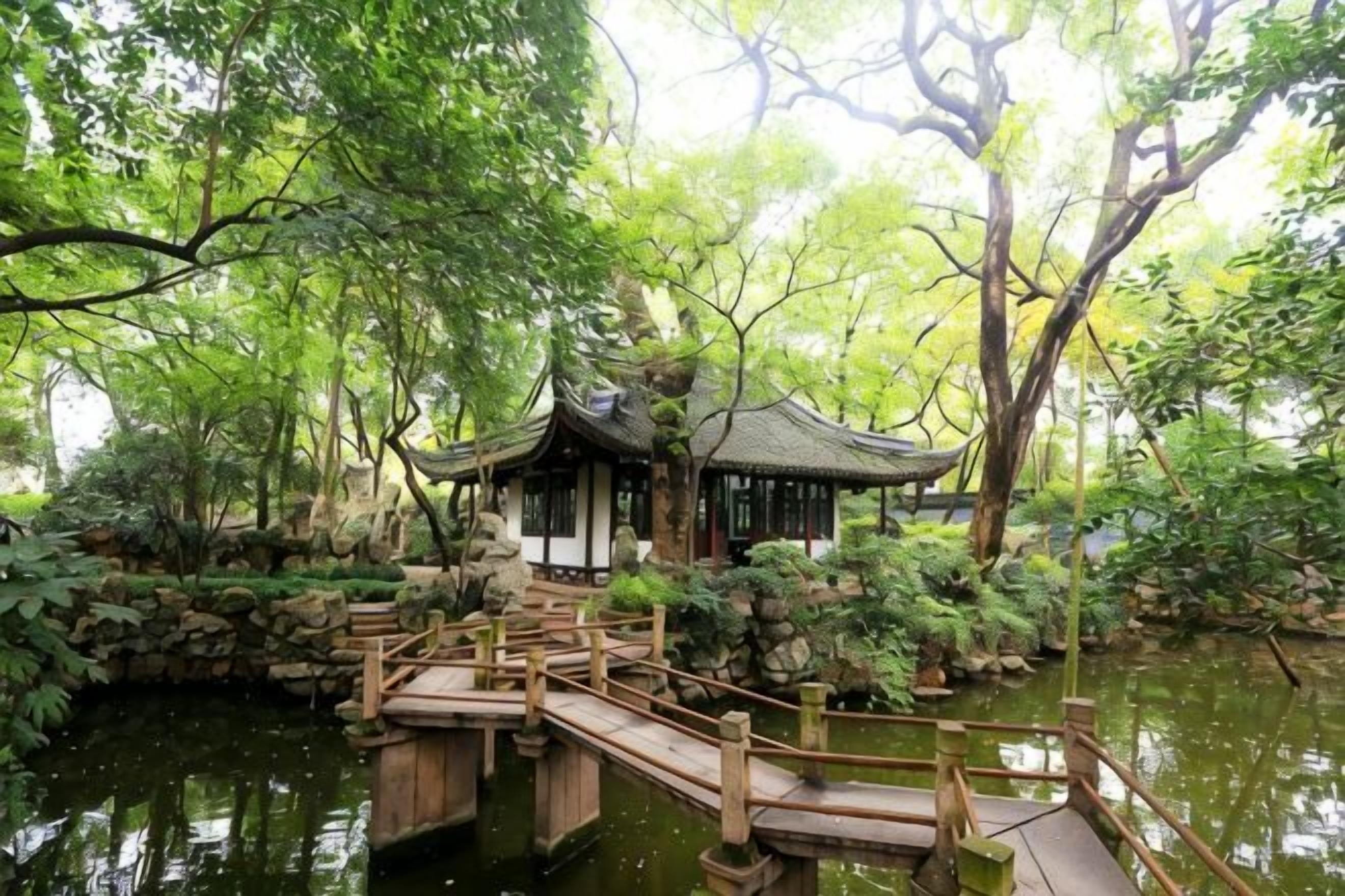 Un pavillon traditionnel surplombant un étang, relié à la rive par un pont en bois, le tout entouré d’une végétation luxuriante.