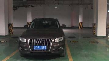 Een auto geparkeerd in een parkeergarage, kenteken zichtbaar.