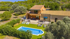 A two-story house with a swimming pool, surrounded by greenery and trees. - Villa Es Garrover (Alcúdia)