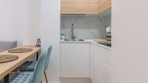 A compact kitchen with white cabinets, a wooden countertop, and a built-in microwave. - Home2Book Modern Studio in Las Palmas, Only Adults (Las Palmas de Gran Canaria)
