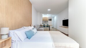 A modern hotel room with a large bed, a desk, and a TV. - Home2Book Modern Studio in Las Palmas, Only Adults (Las Palmas de Gran Canaria)
