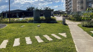Un complejo residencial moderno con piscina, zona de estar exterior y césped cuidado.