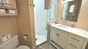 Un baño con ducha, inodoro, lavabo y armario.