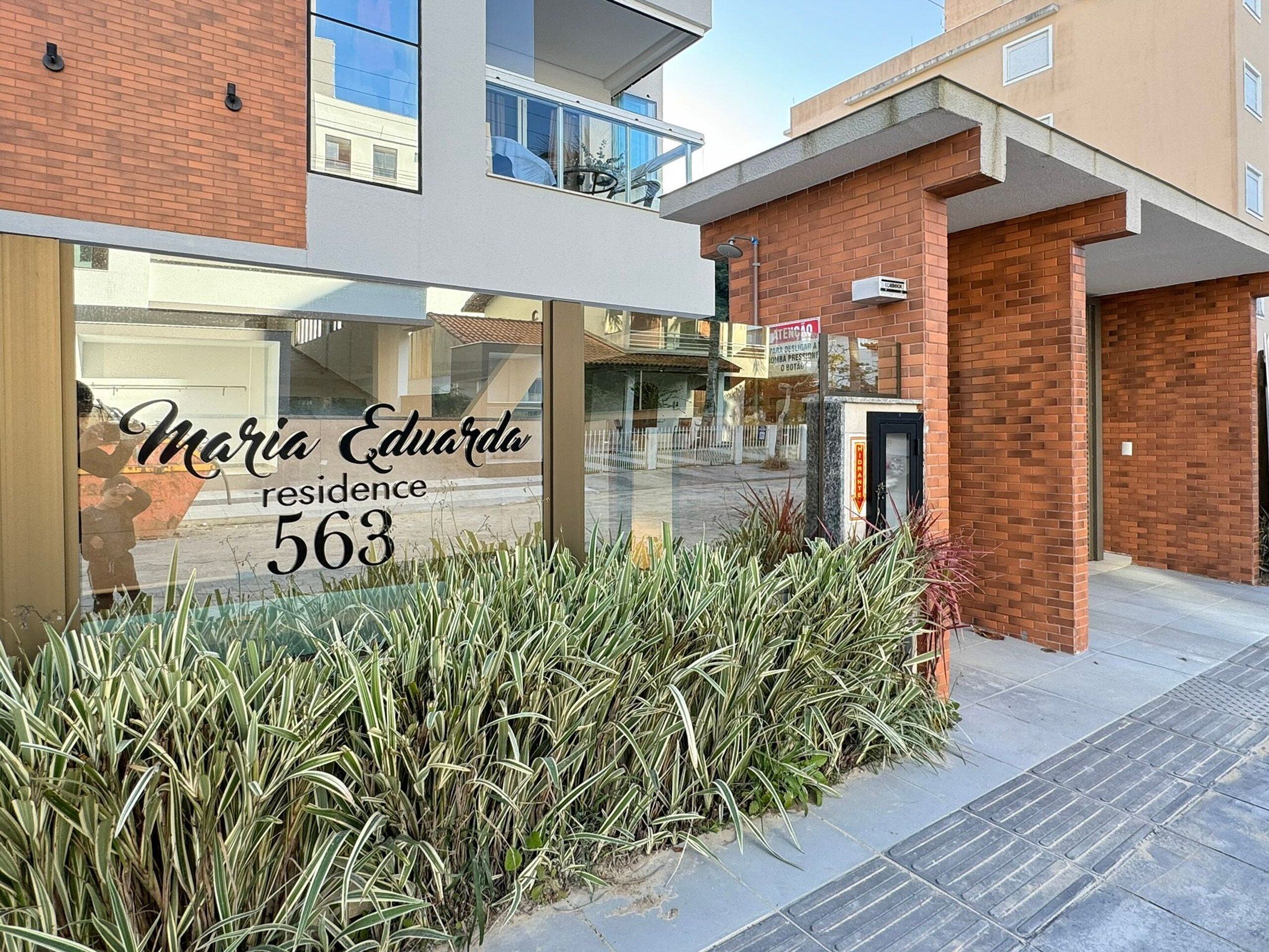 Un edificio moderno con un cartel que dice “Maria Eduardo residence 563”.
