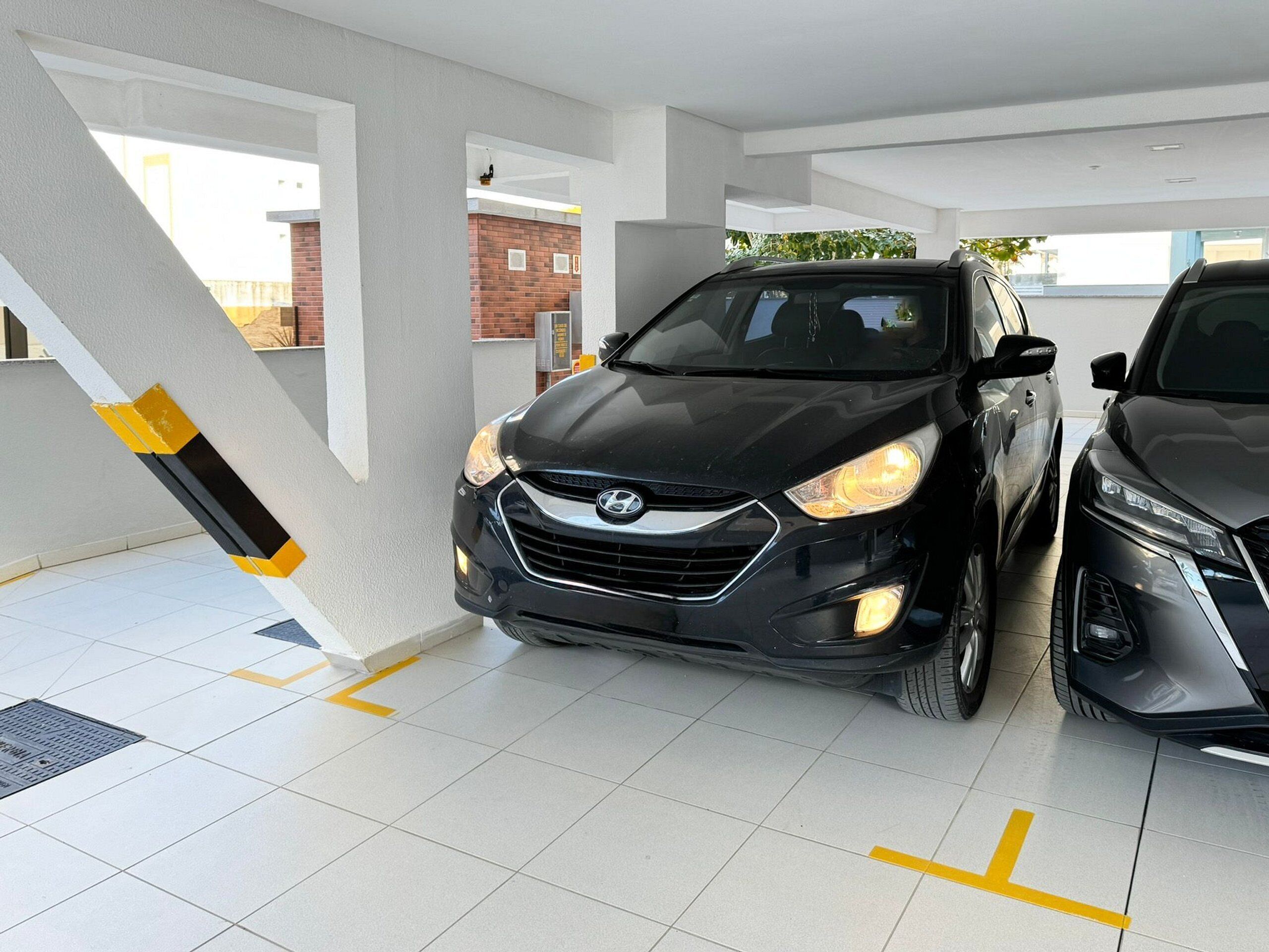 Un estacionamiento con dos autos estacionados uno al lado del otro.