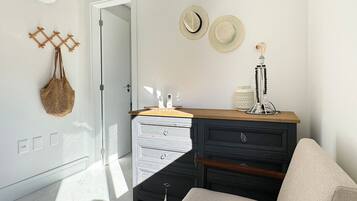Una habitación moderna con un aparador de madera, un banco y una puerta que da a otra estancia.