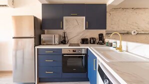 A modern kitchen with a built-in oven, microwave, and a coffee maker.