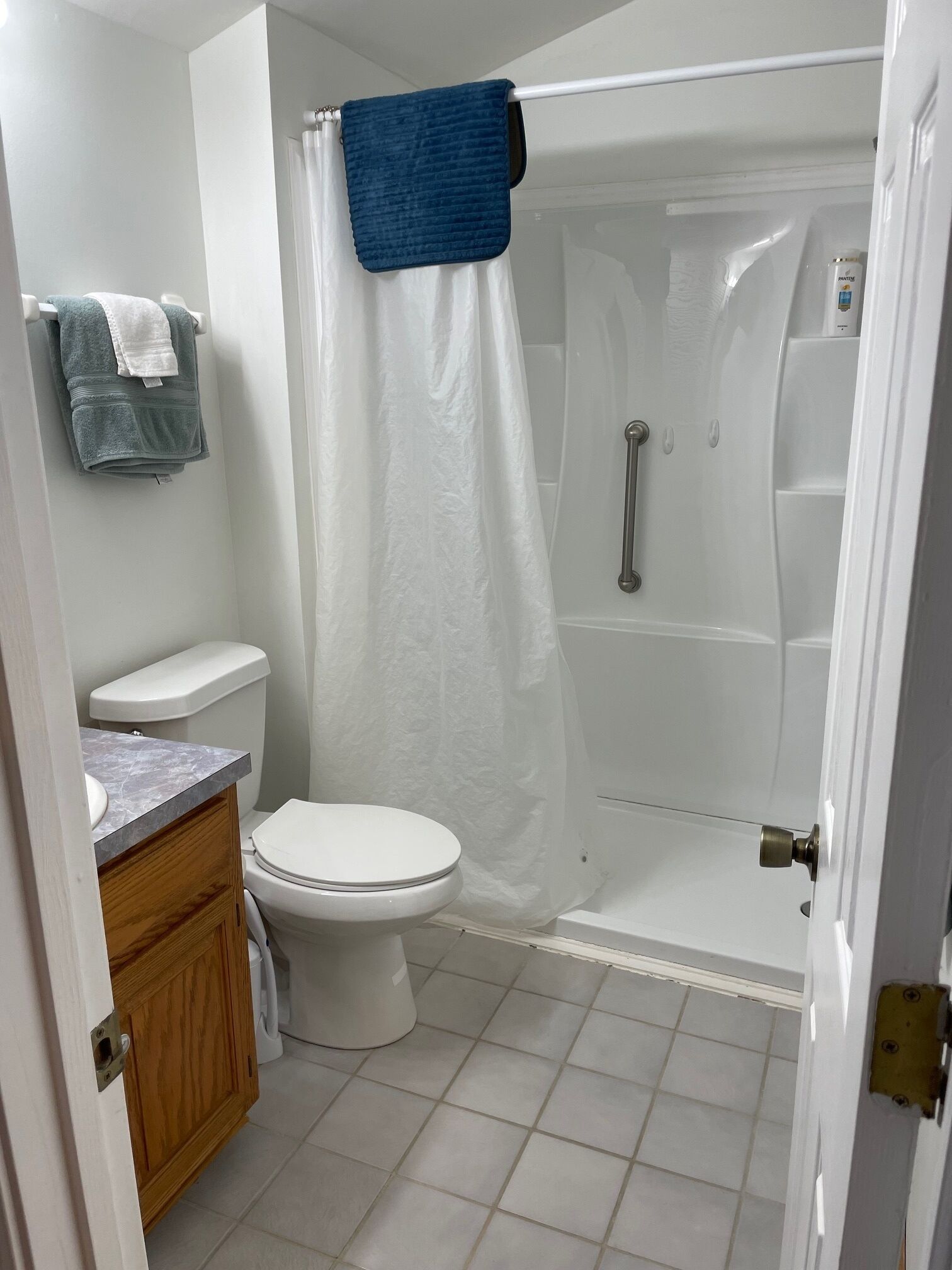 A bathroom with a toilet, a shower enclosure, and a sink.