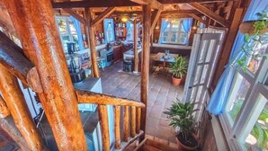 A rustic wooden interior with a staircase leading to a dining area and kitchen. - Oceanfront King Room with Private Balcony, Pool & A/C (Pochomil)