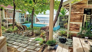 A pool area with lounge chairs, a barbecue grill, and a view of the beach. - 2 Beachfront casitas for 8 w Pool & AC, Wifi (Pochomil)