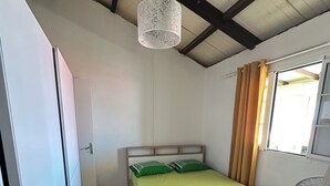 A bedroom with a bed, a ceiling fan, and a window with curtains. - Lovely 160 m2 house with sea view (Vieux-fort)