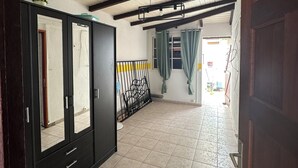 A hallway with tiled flooring, a wooden door frame, and a black wardrobe with mirrored doors. - Lovely 160 m2 house with sea view (Vieux-fort)