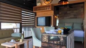 A cozy living area with a sofa, a dining table, a TV, and a kitchen counter. - Los Muertos Beach Walking Distance Suite - C406 (Puerto Vallarta)