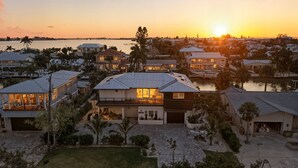 Zona residencial con casas, un puerto deportivo y una puesta de sol.