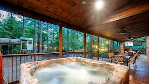 A hot tub in a wooden deck area with a view of trees. - Simmer Down: Shuffleboard, Pool Table, Hot Tub, Firepit, Sleeps 17 (Broken Bow)