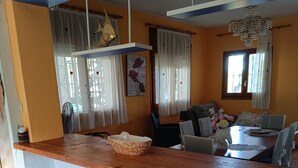 A kitchen with a wooden countertop, a sink, and a window with curtains. - Villa Teresa (L´Ametlla de Mar)