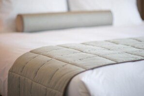 A neatly made bed with a quilted headboard and a white pillow. - Hotel Noto Marina Vista Mare (Noto)