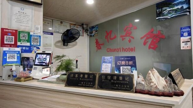A hotel reception area with a clock, registration desks, and informational posters.