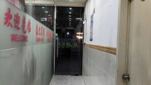 A hallway with a 'WELCOME' sign and a glass door leading to a room.
